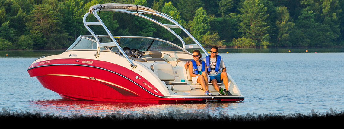 Two people relaxing on a boat on an open lake